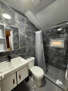 a bathroom with a toilet and a sink at Corner house in Kobuleti +22 photos