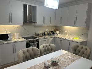 a kitchen with white cabinets and a table and chairs at Villa K & N in Sarandë