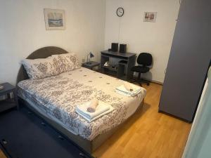 a bedroom with a bed with towels and a desk at Apartman Kostadinovic in Pirot