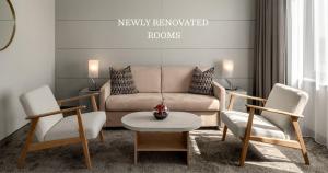 a living room with a couch and two chairs and a table at Ramada by Wyndham Essen in Essen