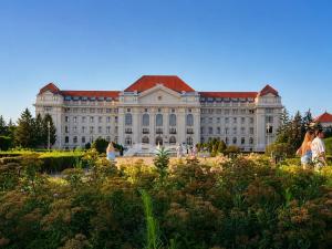 a large building with a garden in front of it at Greatforest apartman 2 in Debrecen