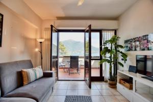 a living room with a couch and a television at 2-Bedroom Airconditioned Lakeview Apartment in Acquaseria