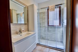a bathroom with a sink and a shower at 2-Bedroom Airconditioned Lakeview Apartment in Acquaseria +59 photos