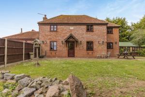 a brick house with a fence and a yard at 3 Bed in Acle oc-b41410 in Acle