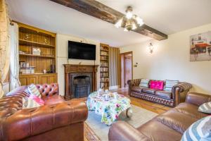 a living room with leather furniture and a fireplace at 3 Bed in Acle oc-b41410 in Acle