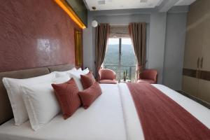 a bedroom with a large bed with red and white pillows at 3 BEDROOMS Premium Private Cottage In Murree Mountains in Murree +142 photos