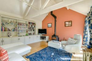 a living room with orange walls and white furniture at 3 Bed in Briningham oc-s44878 in Banningham