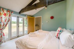 a bedroom with a large bed with white sheets at 3 Bed in Briningham oc-s44878 in Banningham