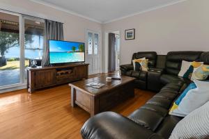 a living room with a couch and a flat screen tv at Tranquility Point in Raymond Island