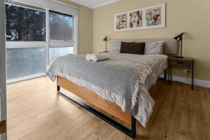 a bedroom with a bed and two windows at Koalas Songs in Raymond Island