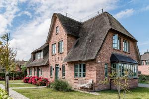 an old brick building with a thatched roof at Waaster Bob in Oldsum
