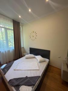 a bedroom with a bed with a clock on the wall at best hotel yerevan in Yerevan +16 photos