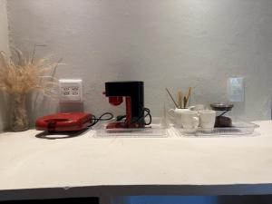 a counter with a sewing machine and cups on it at Apartamentos Ouro Verde in Angra dos Reis