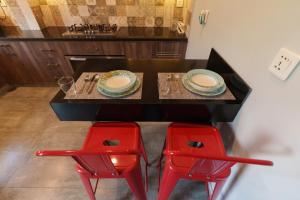 a table with two red chairs and a table with plates at 3 BEDROOMS Premium Private Cottage In Murree Mountains in Murree