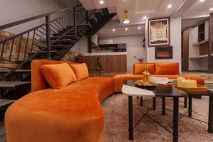 a living room with an orange couch and a table at 3 BEDROOMS Premium Private Cottage In Murree Mountains in Murree