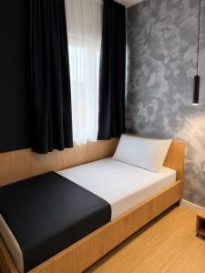 a bedroom with a bed with a white mattress and a window at NOOR Boutique Hotel in Koplik +4 photos
