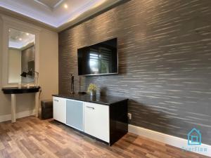 a room with a wall with a television on it at NaWypasie Apartment with Sauna Beautiful Garden SUP Board and Just 30 Minutes from Gdańsk and Gdynia in Szemud