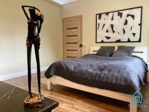 a bedroom with a bed with a statue in the foreground at NaWypasie Apartment with Sauna Beautiful Garden SUP Board and Just 30 Minutes from Gdańsk and Gdynia in Szemud