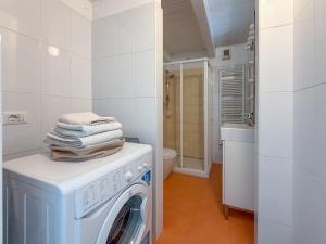 a white laundry room with a washer and dryer at Roma 17 in Cassina deʼ Pecchi +4 photos