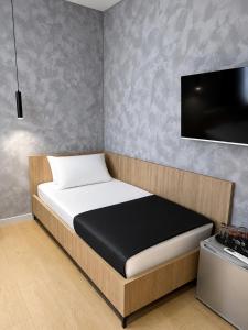 a bedroom with a bed and a flat screen tv at NOOR Boutique Hotel in Koplik