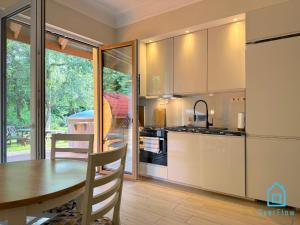 a kitchen with a table and a dining room at NaWypasie Apartment with Sauna Beautiful Garden SUP Board and Just 30 Minutes from Gdańsk and Gdynia in Szemud