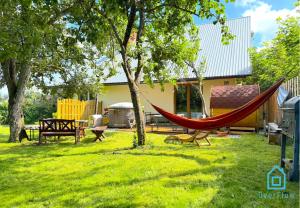 a hammock in the yard of a house at NaWypasie Apartment with Sauna Beautiful Garden SUP Board and Just 30 Minutes from Gdańsk and Gdynia in Szemud
