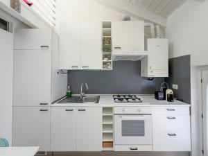 a white kitchen with white cabinets and a sink at Roma 17 in Cassina deʼ Pecchi