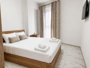 a bedroom with a large bed with two towels on it at AVI GARDEN Apartments in Constanţa
