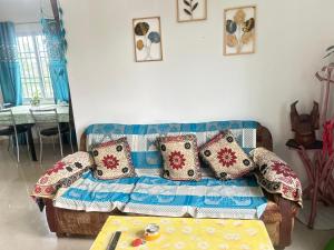 a living room with a couch with pillows on it at JAJABAR Homestay in Dum Duma