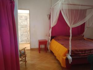 a bedroom with a bed with a canopy at Al Mar Bed and Breakfast in Watamu