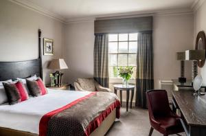 a hotel room with a bed and a desk and a window at Wood Hall Hotel & Spa in Wetherby +34 photos