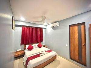 a bedroom with a bed and a red window at Hotel Happinex Inn in Surat