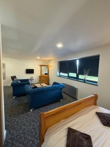 a living room with two blue couches and a flat screen tv at Motel Anić in Novi Travnik