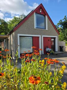 a house with a lot of flowers in front of it at Westmains Lodge in Callander