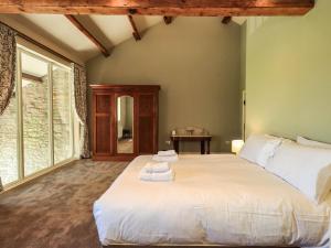 a bedroom with a large bed with towels on it at Ragged Hall Barn in Settle
