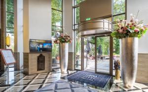 a lobby with two vases with flowers in it at Grand Hotel Valies in Roermond