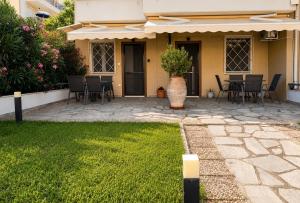 a patio with chairs and a table in front of a house at AZEK Garden Suite in Perea