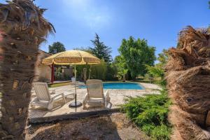 two chairs and an umbrella next to a pool at L'Etable de Sauvignac - Avec piscine privée in Sauvignac