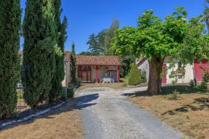 a driveway leading to a house with a tree at L'Etable de Sauvignac - Avec piscine privée in Sauvignac