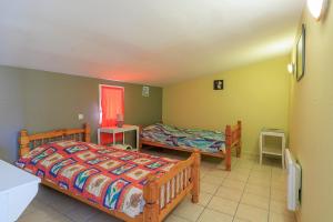 a bedroom with two beds and two tables at L'Etable de Sauvignac - Avec piscine privée in Sauvignac +13 photos