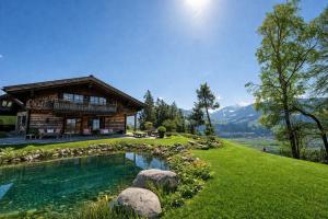 a log house with a pond in front of it at Jagdhaus Umlberg in Umlberg