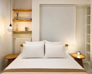 a bedroom with a bed with white sheets and wooden tables at AZEK Garden Suite in Perea