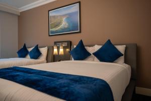 a hotel room with two beds with blue pillows at Hotel & Casino Internacional Valencia in Valencia