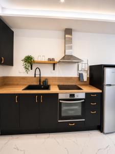 a kitchen with black cabinets and a sink at AZEK Garden Suite in Perea +4 photos