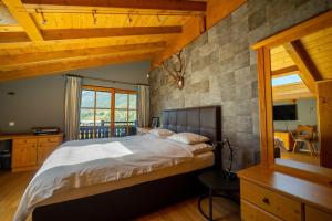 a bedroom with a large bed with a stone wall at Jagdhaus Umlberg in Umlberg
