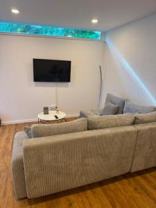 a living room with a couch and a flat screen tv at Gemütliche City Wohnung in Mönchengladbach