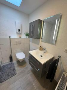 a bathroom with a sink and a toilet and a mirror at Gemütliche City Wohnung in Mönchengladbach +15 photos