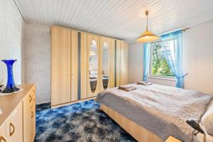 a bedroom with a bed and a large window at Bungalow an der Havel in Margarethenhof
