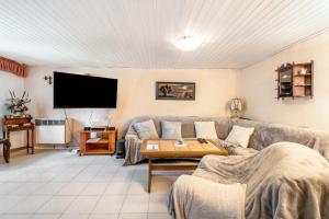 a living room with a couch and a tv at Bungalow an der Havel in Margarethenhof