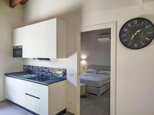 a kitchen with a clock on the wall next to a bed at Apartment in Riga by Interhome in Cisano sul Neva